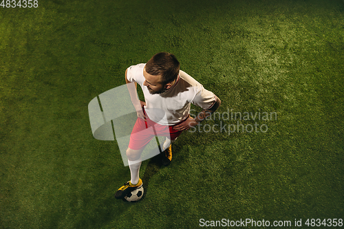 Image of Top view of caucasian football or soccer player on green background of grass