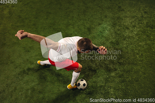 Image of Top view of caucasian football or soccer player on green background of grass