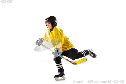 Image of Little hockey player with the stick on ice court and white studio background