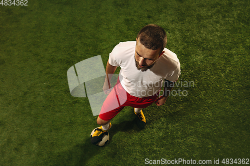 Image of Top view of caucasian football or soccer player on green background of grass