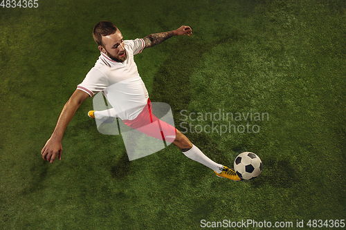 Image of Top view of caucasian football or soccer player on green background of grass