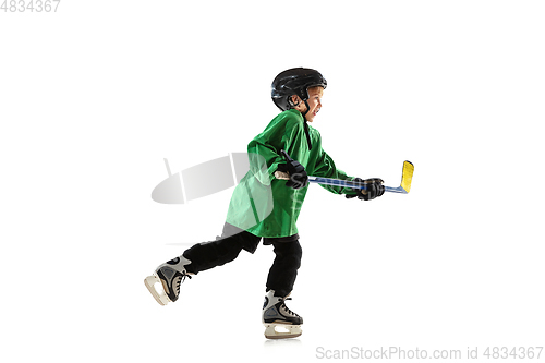 Image of Little hockey player with the stick on ice court and white studio background