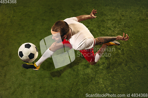 Image of Top view of caucasian football or soccer player on green background of grass