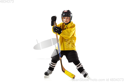 Image of Little hockey player with the stick on ice court and white studio background