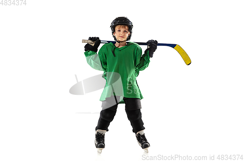 Image of Little hockey player with the stick on ice court and white studio background