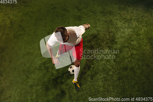 Image of Top view of caucasian football or soccer player on green background of grass