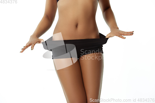 Image of Slim tanned woman\'s body isolated on white studio background