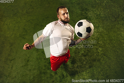 Image of Top view of caucasian football or soccer player on green background of grass