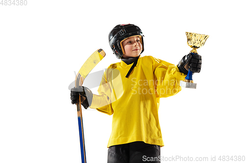 Image of Little hockey player with the stick on ice court and white studio background