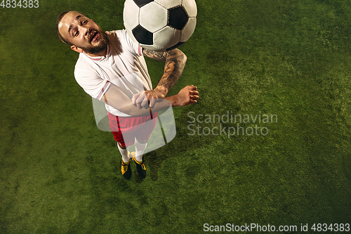 Image of Top view of caucasian football or soccer player on green background of grass