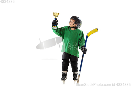 Image of Little hockey player with the stick on ice court and white studio background