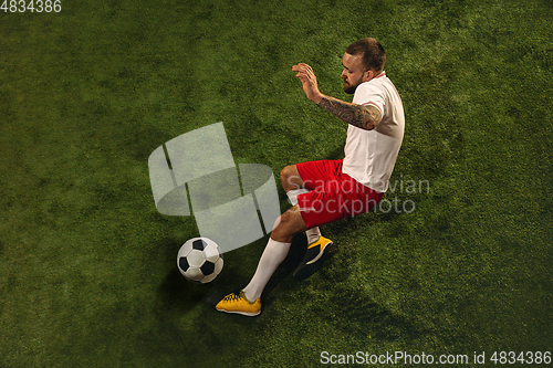 Image of Top view of caucasian football or soccer player on green background of grass