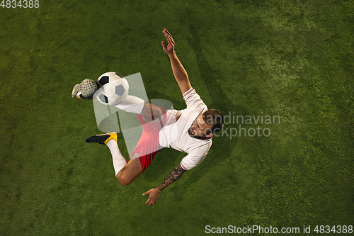 Image of Top view of caucasian football or soccer player on green background of grass