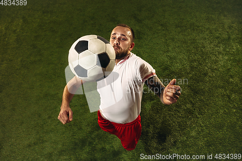 Image of Top view of caucasian football or soccer player on green background of grass