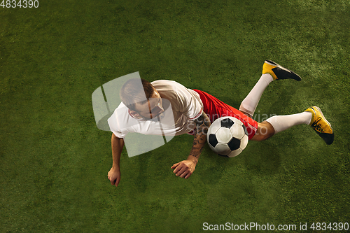 Image of Top view of caucasian football or soccer player on green background of grass