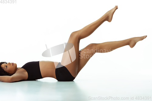 Image of Slim tanned woman\'s body isolated on white studio background