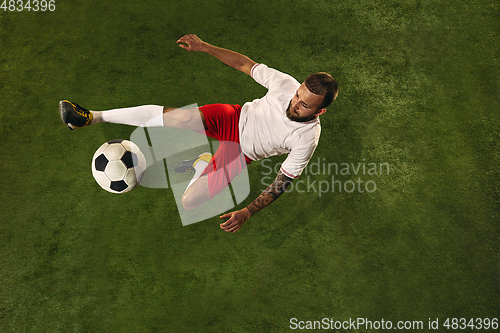 Image of Top view of caucasian football or soccer player on green background of grass