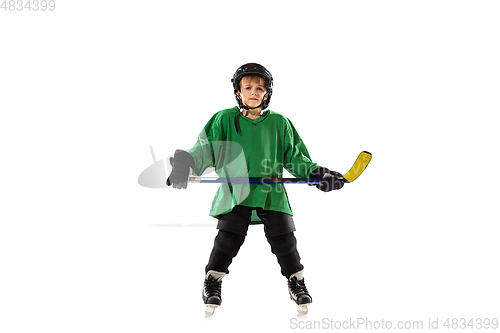 Image of Little hockey player with the stick on ice court and white studio background