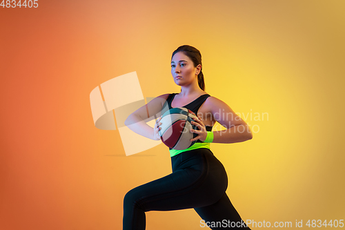 Image of Young caucasian plus size female model\'s training on gradient orange background