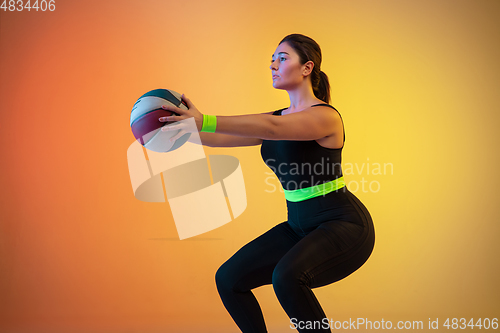 Image of Young caucasian plus size female model\'s training on gradient orange background