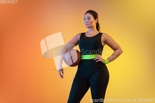 Image of Young caucasian plus size female model\'s training on gradient orange background
