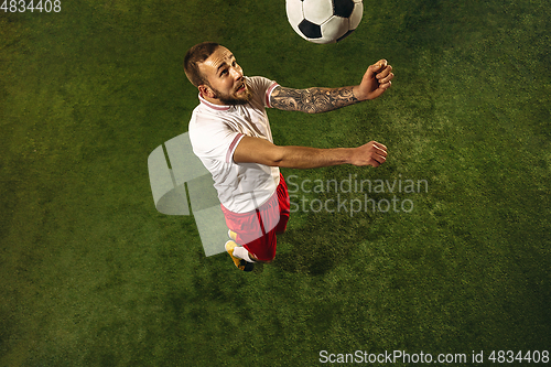 Image of Top view of caucasian football or soccer player on green background of grass
