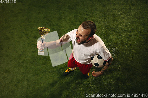 Image of Top view of caucasian football or soccer player on green background of grass