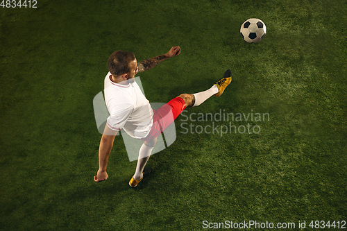 Image of Top view of caucasian football or soccer player on green background of grass