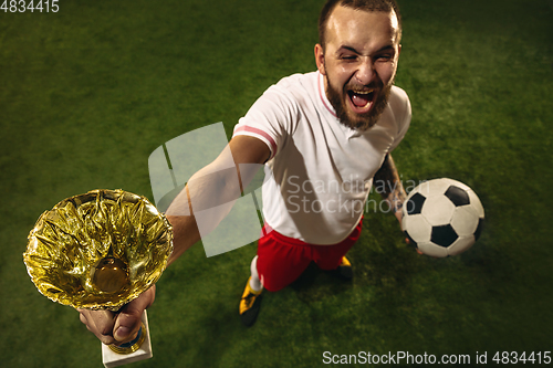 Image of Top view of caucasian football or soccer player on green background of grass