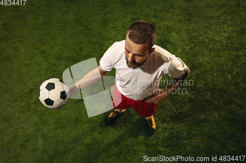 Image of Top view of caucasian football or soccer player on green background of grass