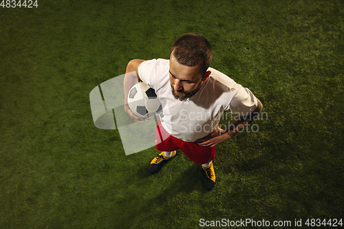 Image of Top view of caucasian football or soccer player on green background of grass