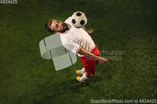 Image of Top view of caucasian football or soccer player on green background of grass