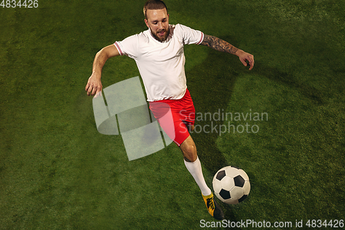 Image of Top view of caucasian football or soccer player on green background of grass