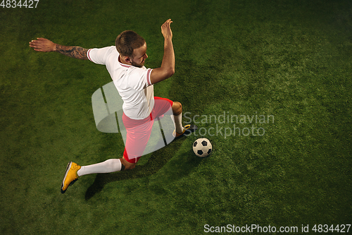 Image of Top view of caucasian football or soccer player on green background of grass