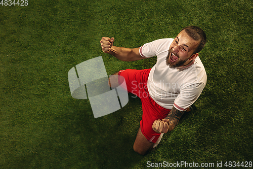 Image of Top view of caucasian football or soccer player on green background of grass