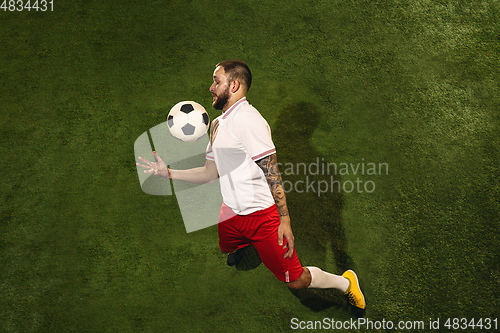 Image of Top view of caucasian football or soccer player on green background of grass