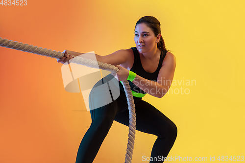 Image of Young caucasian plus size female model\'s training on gradient orange background