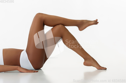 Image of Slim tanned woman\'s body isolated on white studio background