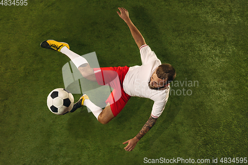 Image of Top view of caucasian football or soccer player on green background of grass