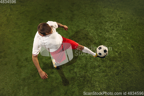 Image of Top view of caucasian football or soccer player on green background of grass