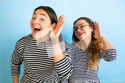 Image of Young emotional women on gradient blue background