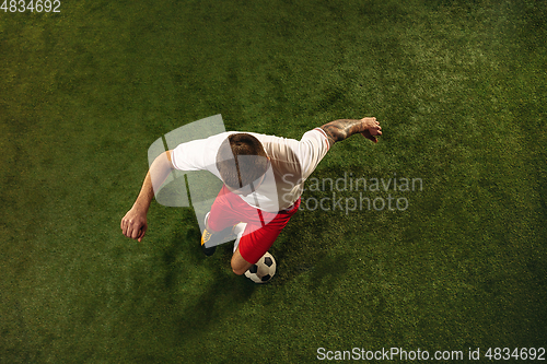 Image of Top view of caucasian football or soccer player on green background of grass