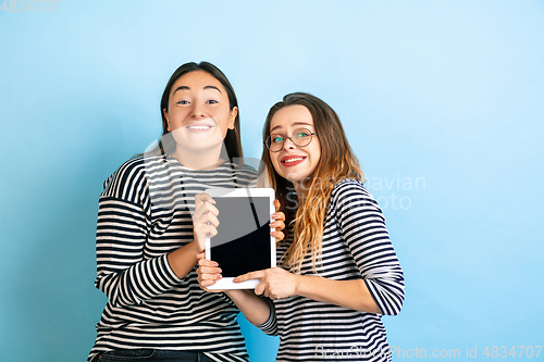 Image of Young emotional women on gradient blue background