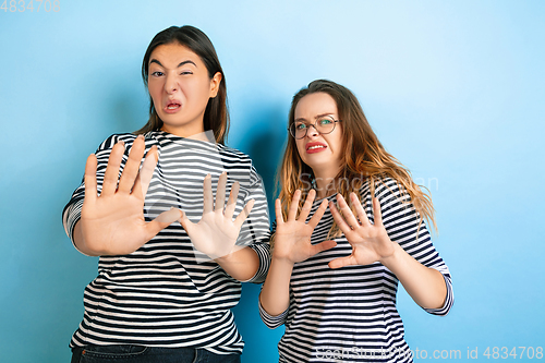 Image of Young emotional women on gradient blue background