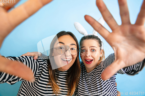 Image of Young emotional women on gradient blue background