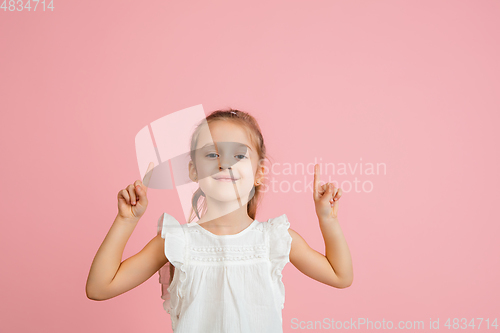 Image of Pretty caucasian girl portrait isolated on pink studio background with copyspace