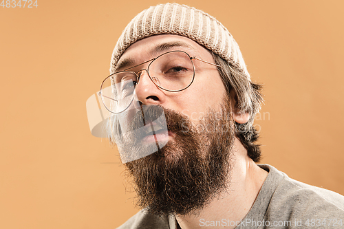 Image of Portrait of Caucasian man in glasses and hat isolated on light background.