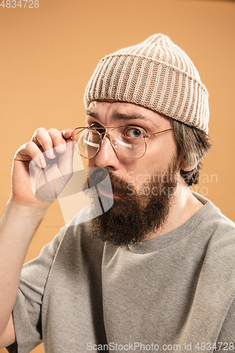 Image of Portrait of Caucasian man in glasses and hat isolated on light background.