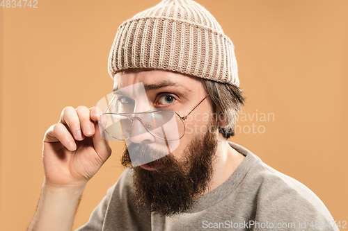 Image of Portrait of Caucasian man in glasses and hat isolated on light background.