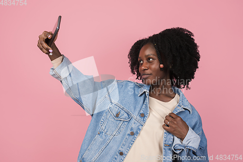 Image of African-american woman portrait isolated on pink studio background with copyspace